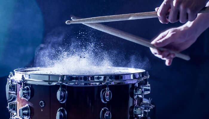 Man plays musical percussion instrument with sticks closeup